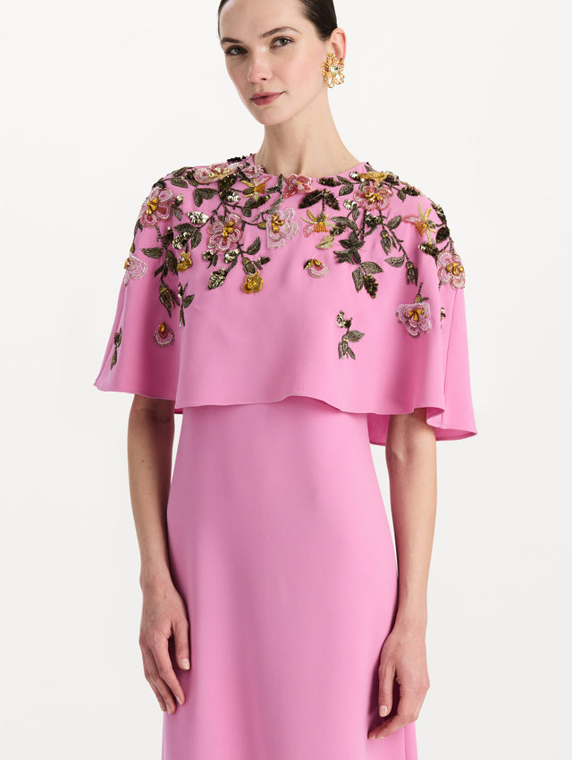 The model is wearing the beaded mixed botanical embroidered caftan in the color pink with floral detailing. Zoom view.
