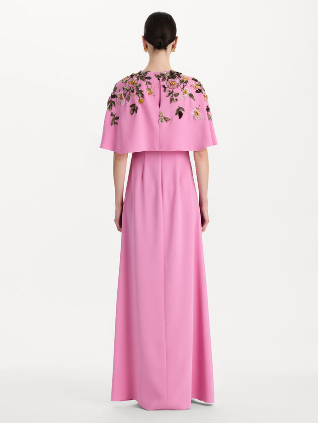 The model is wearing the beaded mixed botanical embroidered caftan in the color pink with floral detailing. Back view. 