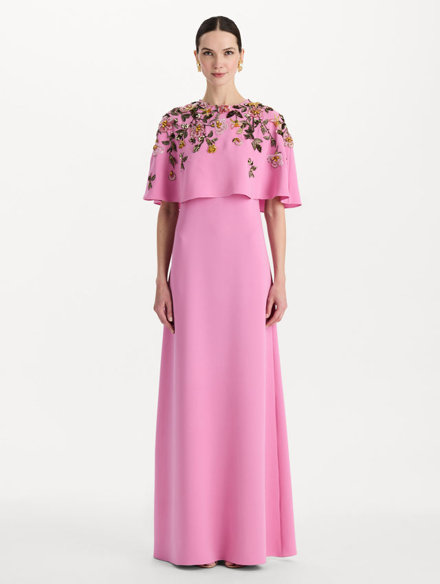 The model is wearing the beaded mixed botanical embroidered caftan in the color pink with floral detailing. Front view.