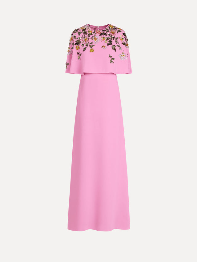The model is wearing the beaded mixed botanical embroidered caftan in the color pink with floral detailing.