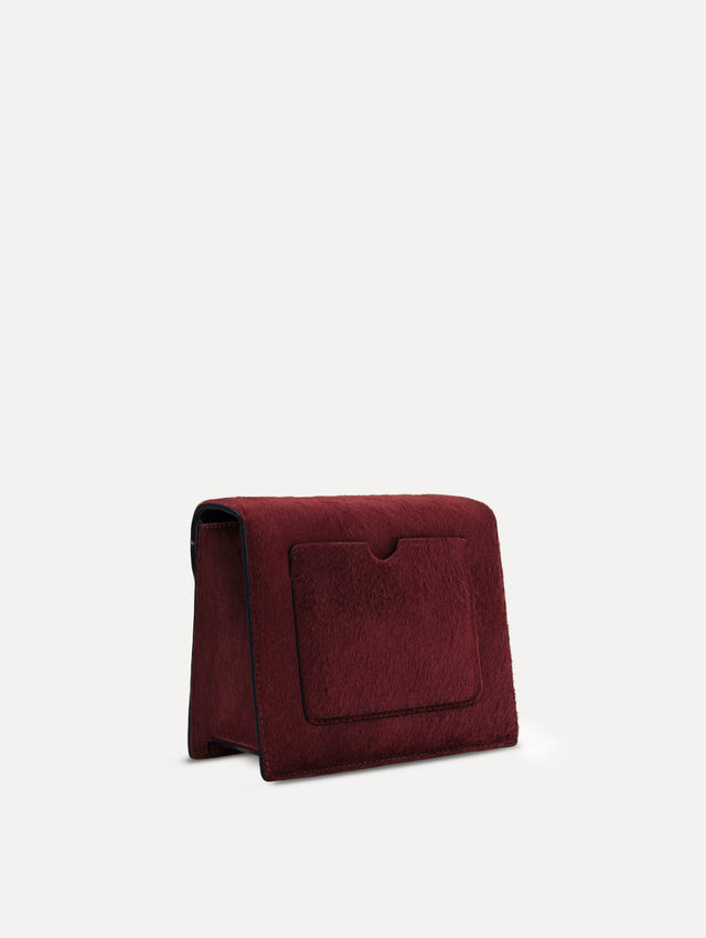 The Haircalf Mini TRO Bag in the color bordeaux. Back view.
