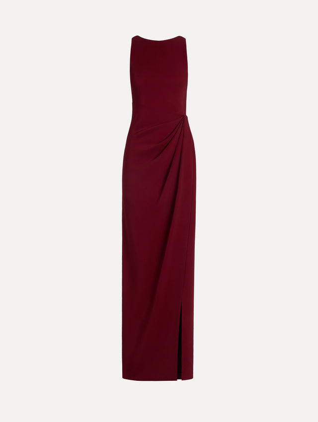 The model is wearing the drape-detailed cady gown with a sleeveless silhouette in the color claret.