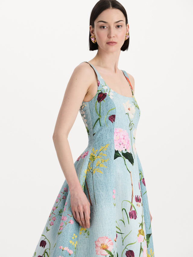 The model is wearing the mixed botanical faille gown with a sleeveless scoop neckline and a bold floral print in blue multi. Zoom view. 