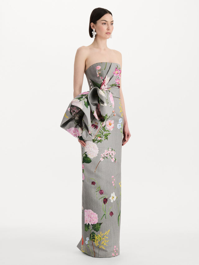 The model is wearing the mixed botanical drape-detailed faille gown with a strapless silhouette in the color grey multi. Side view. 
