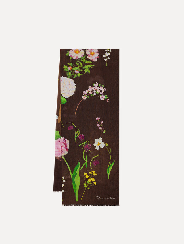 The model is wearing the mixed botanical scarf with an all-over floral print in the color brown. 