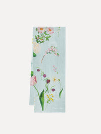 The model is wearing the mixed botanical scarf with an all-over floral print in the color light blue multi. 