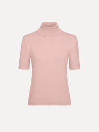 The model is wearing the turtleneck wool short-sleeve pullover with a fold-over neckline in the color blush. 