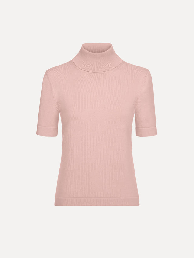 The model is wearing the turtleneck wool short-sleeve pullover with a fold-over neckline in the color blush. 