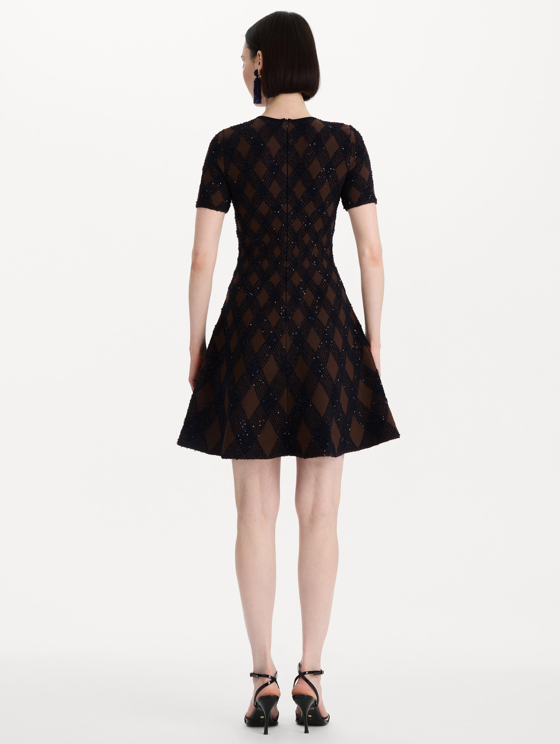 The model is wearing the argyle knit dress with a fit-and-flare silhouette in navy and brown. Back view.