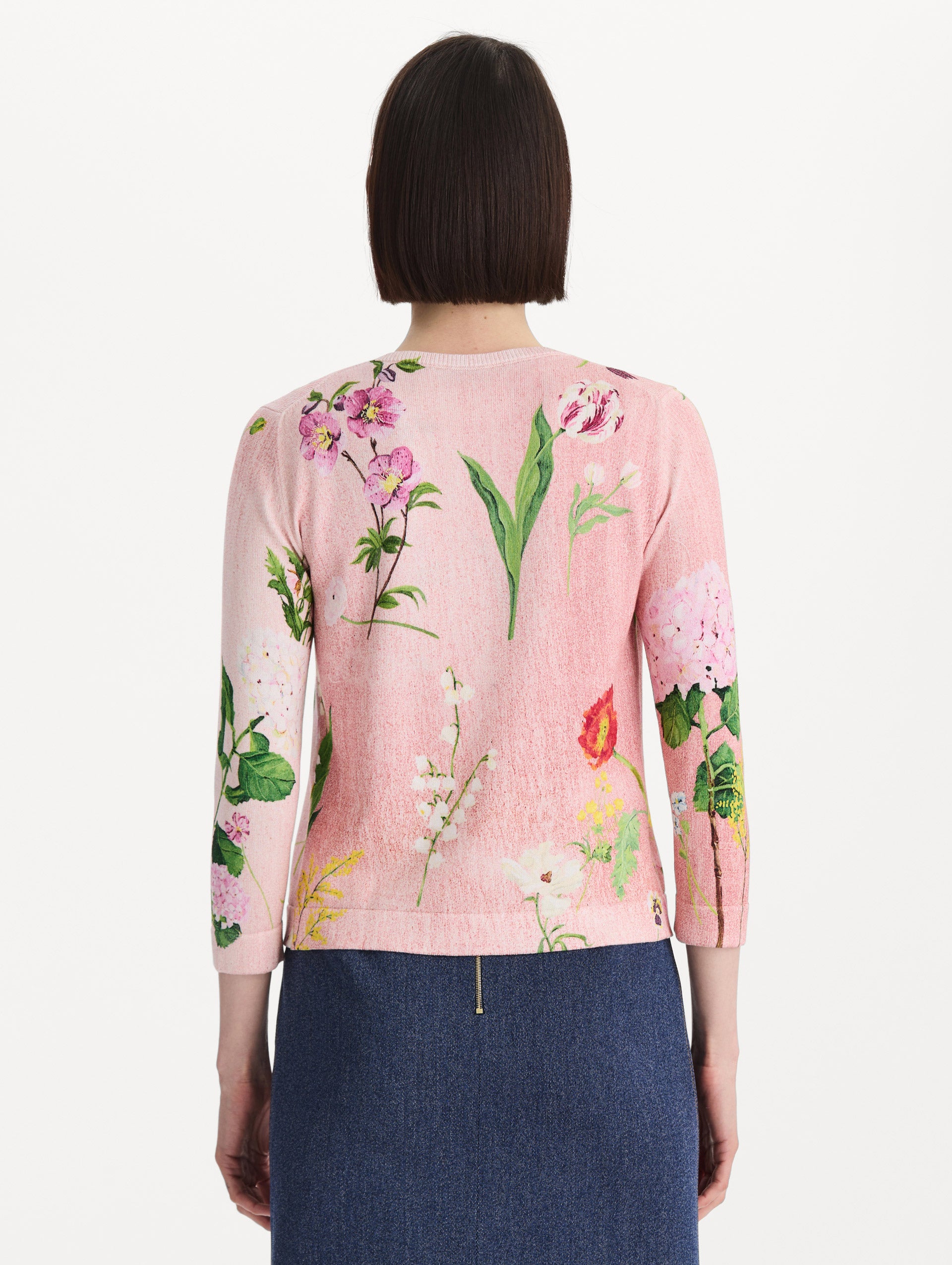 The model is wearing the mixed botanical tie-neck cardigan with an all-over floral print in blush multi. Back view.