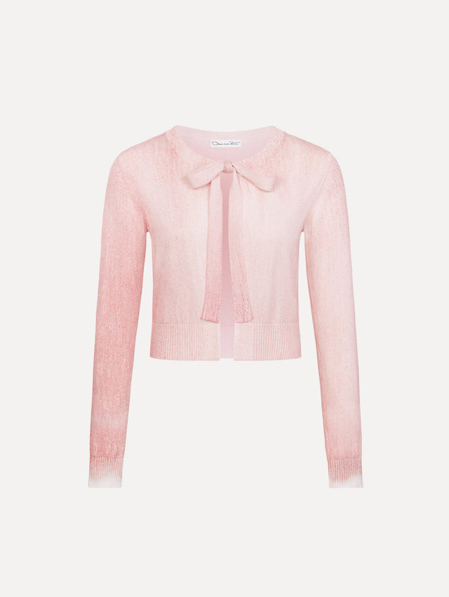 The model is wearing the botanical tie-neck cardigan with a floral print in the color blush.