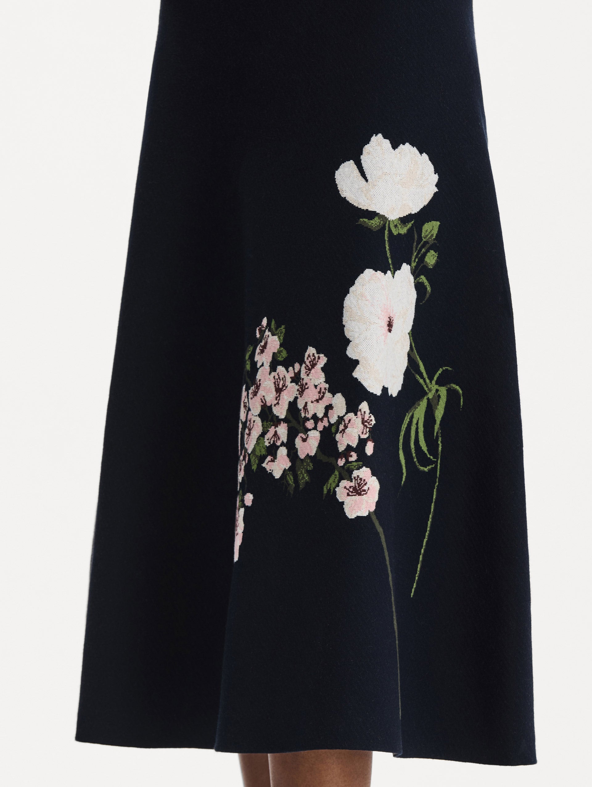 The model is wearing the mixed botanical jacquard dress with long sleeves in the color navy. Zoom view. 