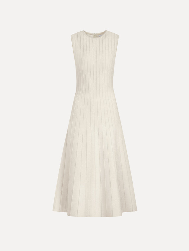 The model is wearing the ottoman knit dress in the color ivory with metallic sparkle yarn detailing.