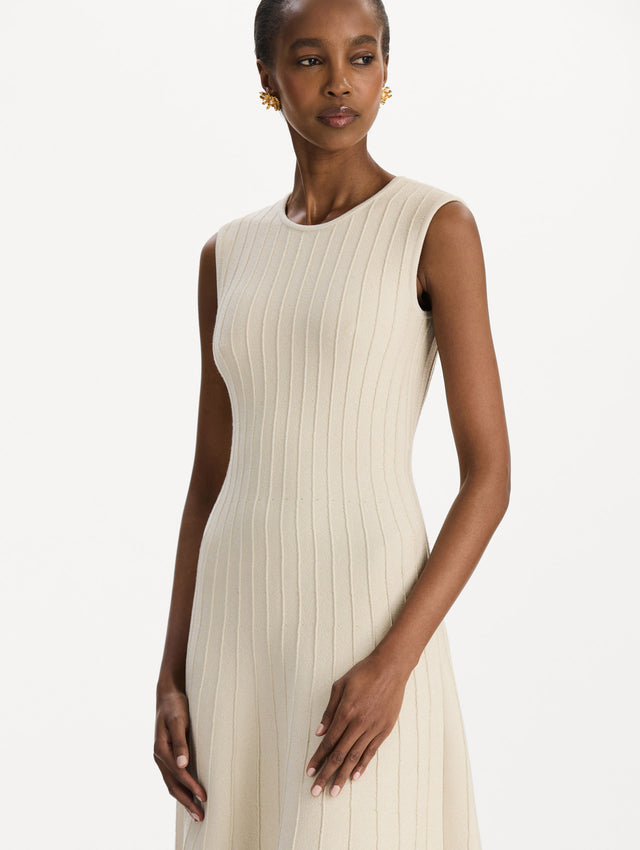 The model is wearing the ottoman knit dress in the color ivory with metallic sparkle yarn detailing. Zoom view. 
