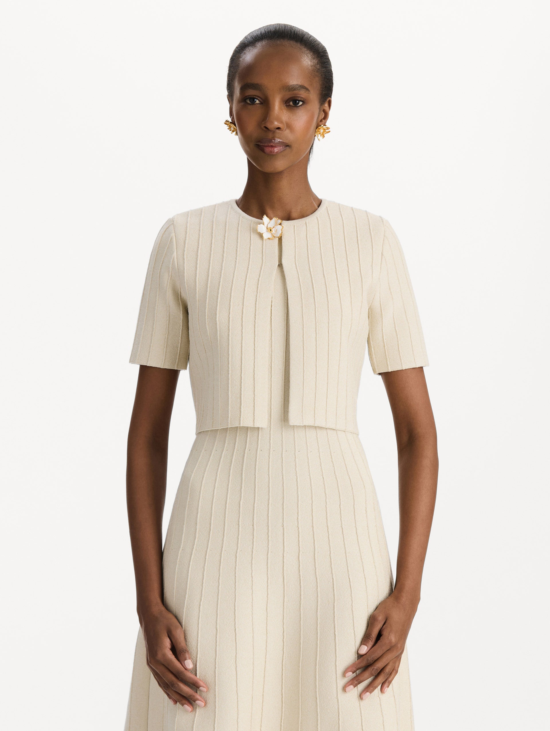 The model is wearing the ottoman cropped cardigan with sparkle yarn detailing in the color ivory. Front view.