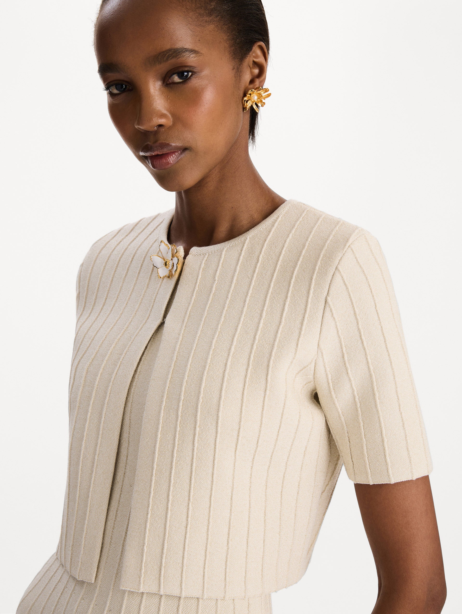 The model is wearing the ottoman cropped cardigan with sparkle yarn detailing in the color ivory. Zoom view.