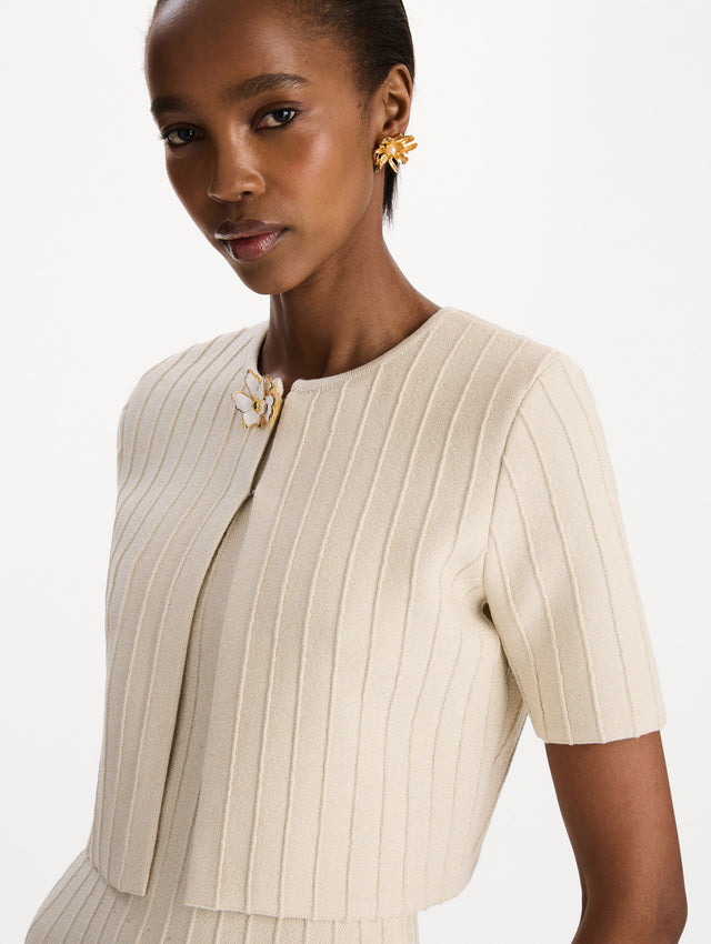 The model is wearing the ottoman cropped cardigan with sparkle yarn detailing in the color ivory. Zoom view.