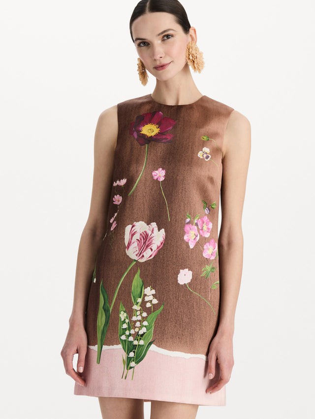 The model is wearing the mixed botanical shift dress with a border print and a sleeveless silhouette. Zoom view. 
