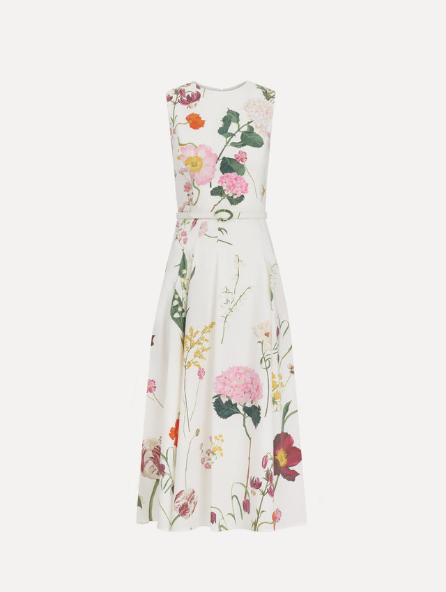 The model is wearing the mixed botanical cotton poplin sleeveless dress with an all-over floral print in white multi. 