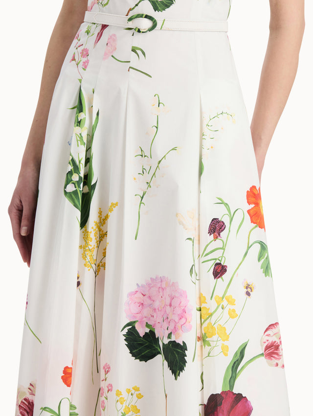 The model is wearing the mixed botanical cotton poplin sleeveless dress with an all-over floral print in white multi. Zoom view. 