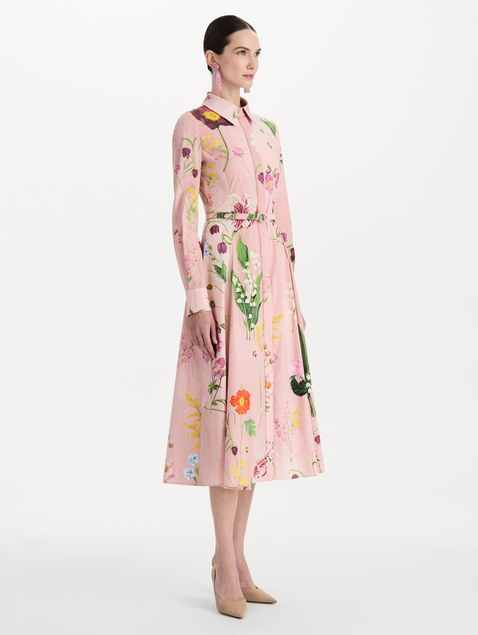 The model is wearing the mixed botanical cotton poplin dress with a collared neckline, long sleeves, and an all-over floral print in blush multi. Side view. 