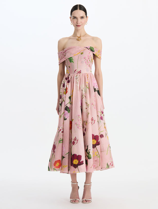The model is wearing the mixed botanical off-shoulder dress in organic cotton with a floral print in a blush multi palette. Front view. 