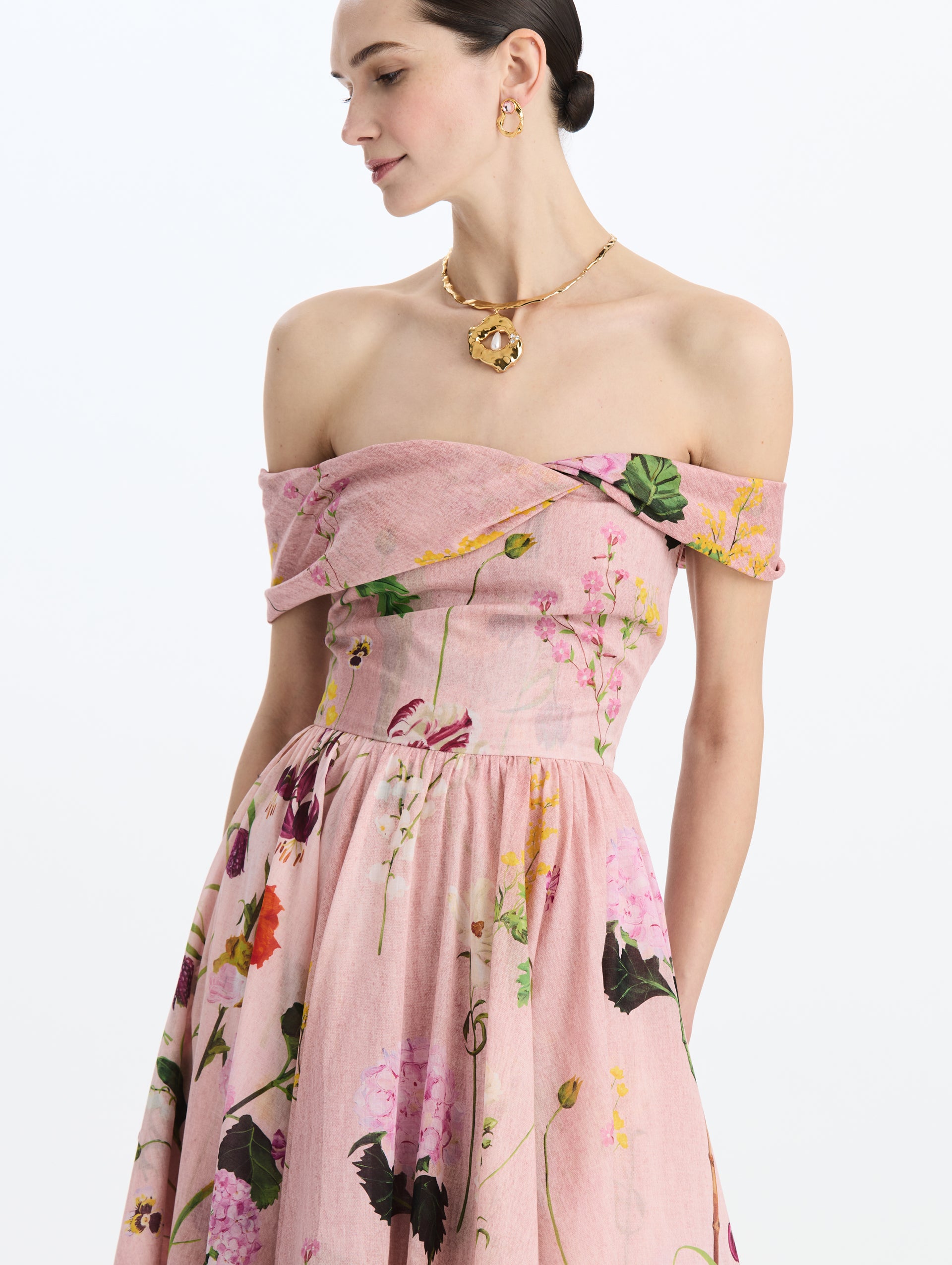 The model is wearing the mixed botanical off-shoulder dress in organic cotton with a floral print in a blush multi palette. Zoom view.