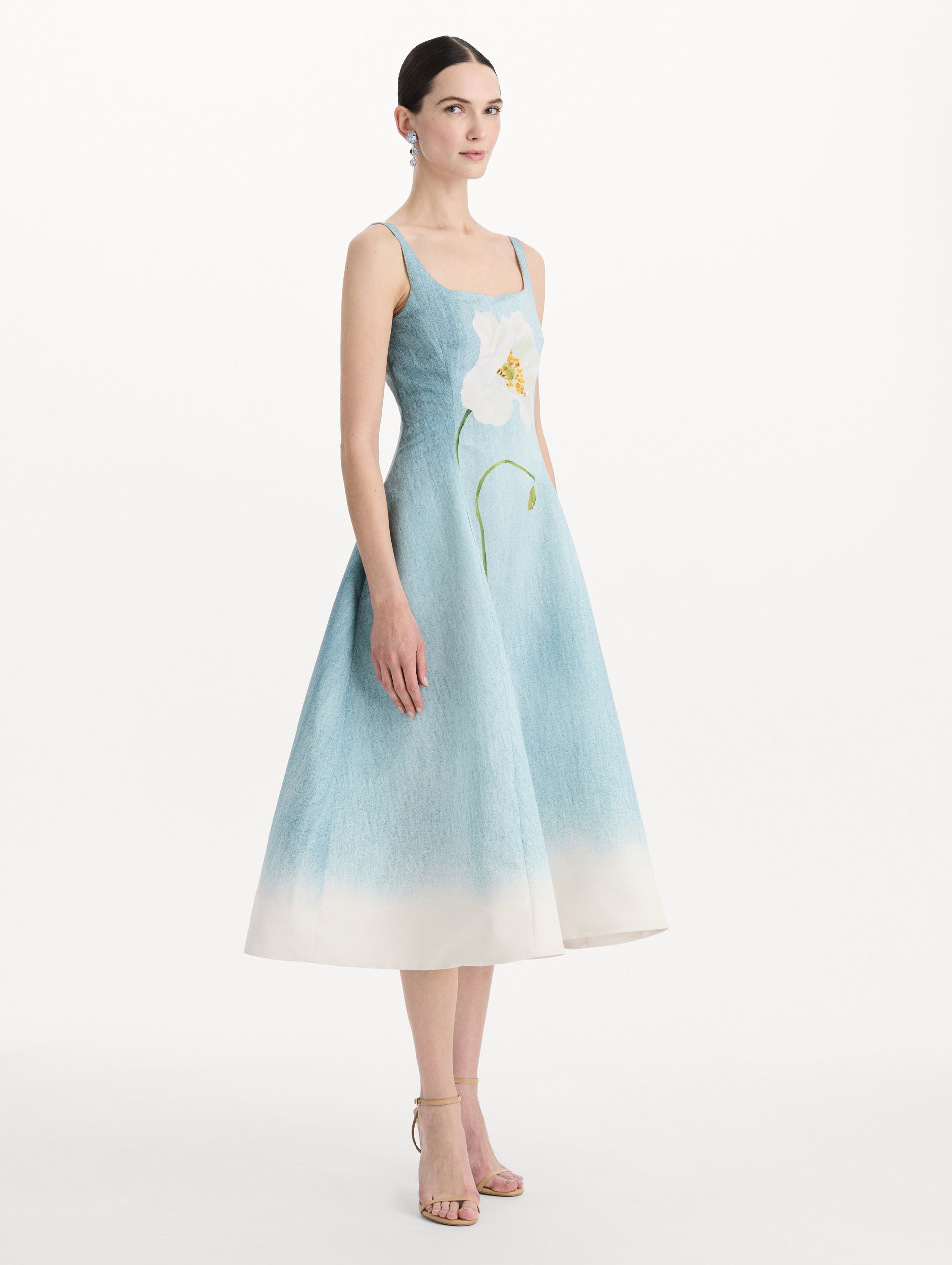 The model is wearing the ombré peony faille dress with a sleeveless scoop neckline in white and blue. Side view. 