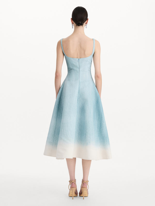 The model is wearing the ombré peony faille dress with a sleeveless scoop neckline in white and blue. Back view. 