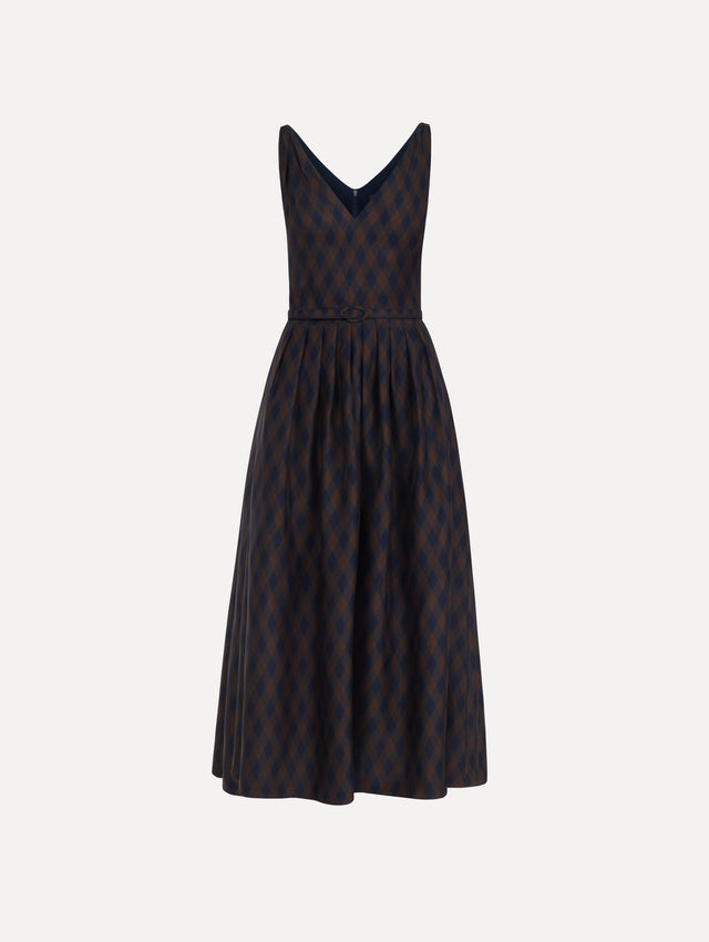 The model is wearing the argyle silk twill dress with a sleeveless silhouette, a V-neckline, and an argyle print in navy and brown.