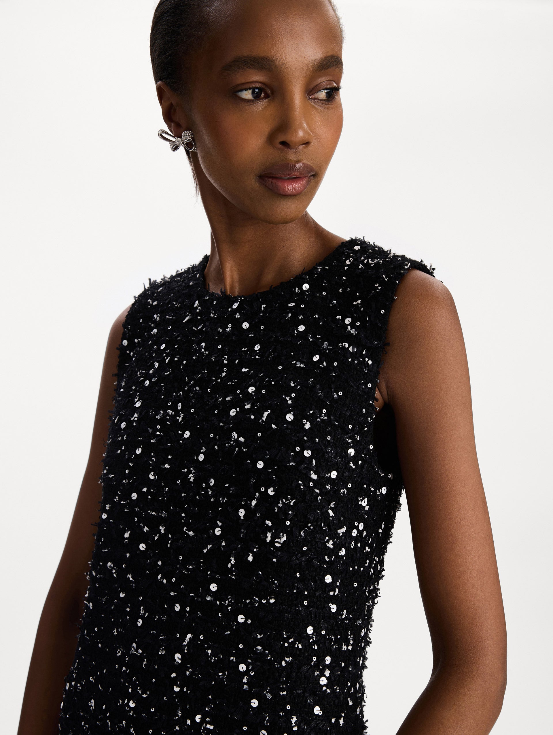 The model is wearing the sequin ribbon tweed sleeveless day dress in black and white. Zoom view. 