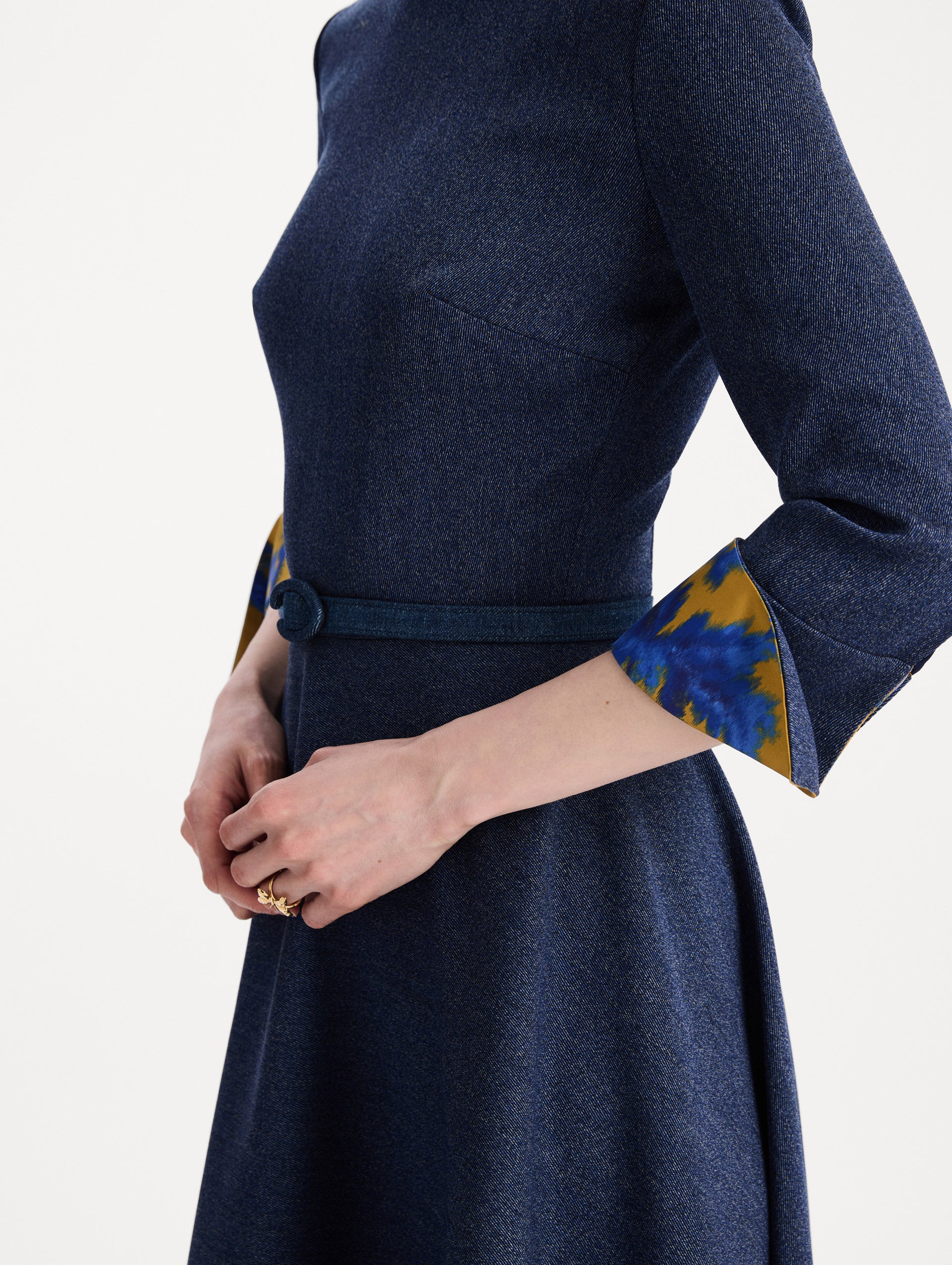 The model is wearing the peony cuff wool dress in the color indigo with peony-print cuffs and midi sleeves. Zoom view. 