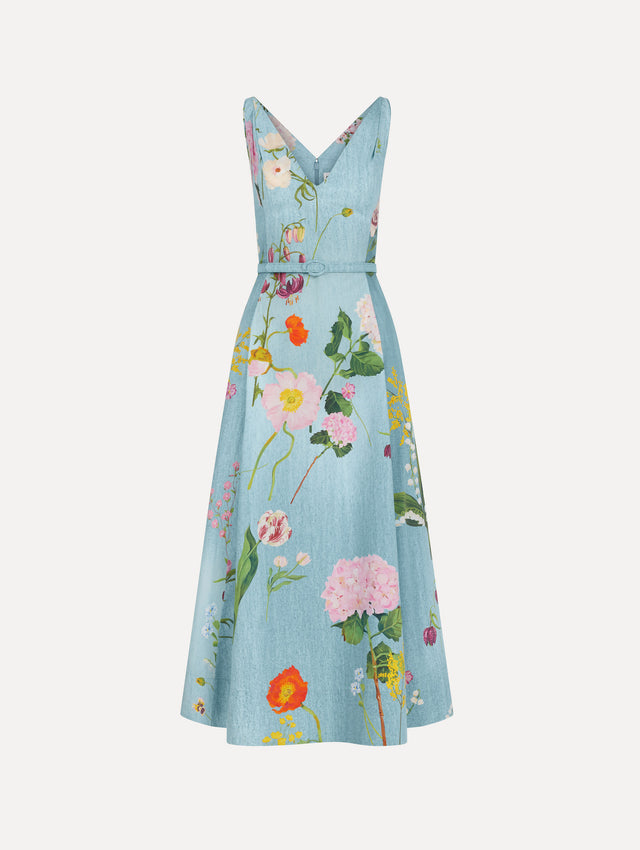 The model is wearing the mixed botanical cotton poplin dress with a sleeveless V-neck silhouette and an all-over floral print in blue multi.