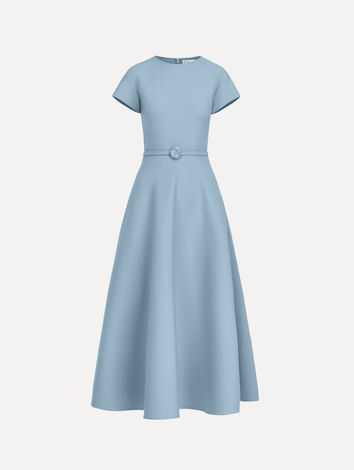 The model is wearing the wool cap sleeve dress in the color talc blue.