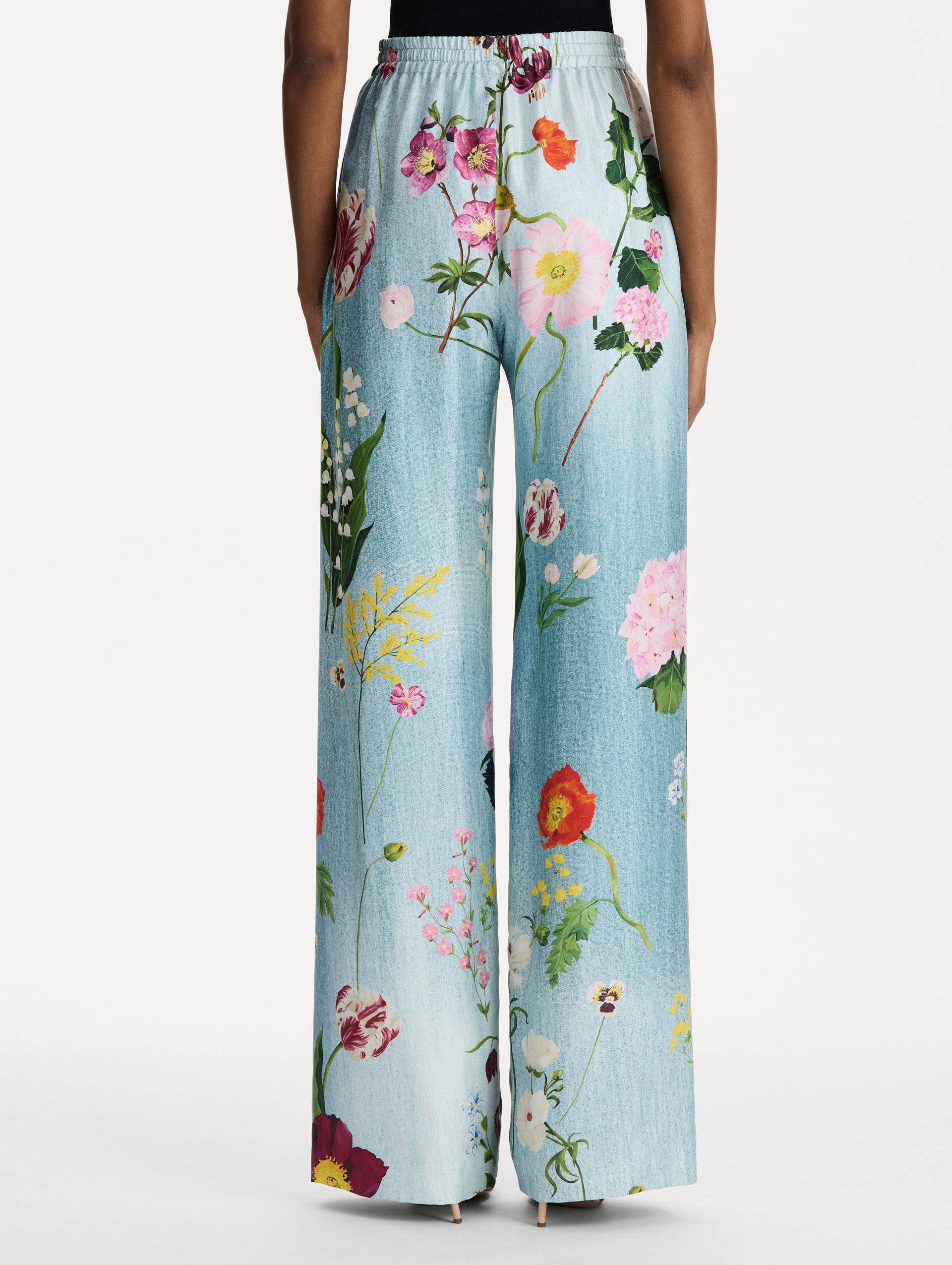 The model is wearing the mixed botanical silk twill pant in the color blue multi. Back view. 