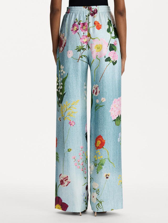 The model is wearing the mixed botanical silk twill pant in the color blue multi. Back view. 