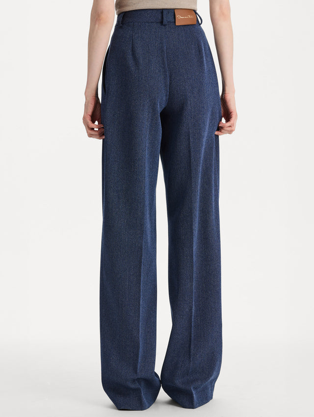 Model wearing indigo wool drill trousers with a straight-leg silhouette. Back view. 
