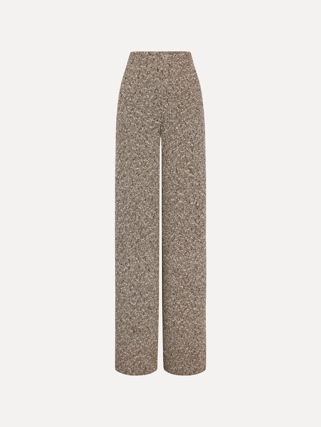 The model is wearing the slubby wool tweed gauze pant with a tailored silhouette in an ivory and brown palette. 