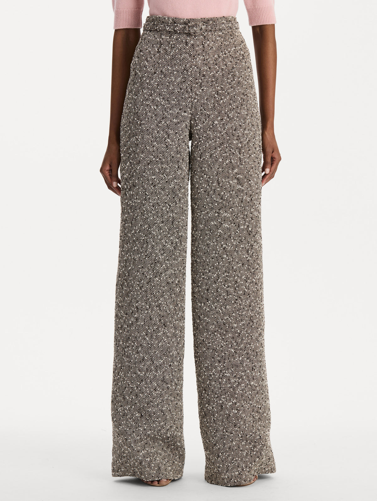 The model is wearing the slubby wool tweed gauze pant with a tailored silhouette in an ivory and brown palette. Front view. 