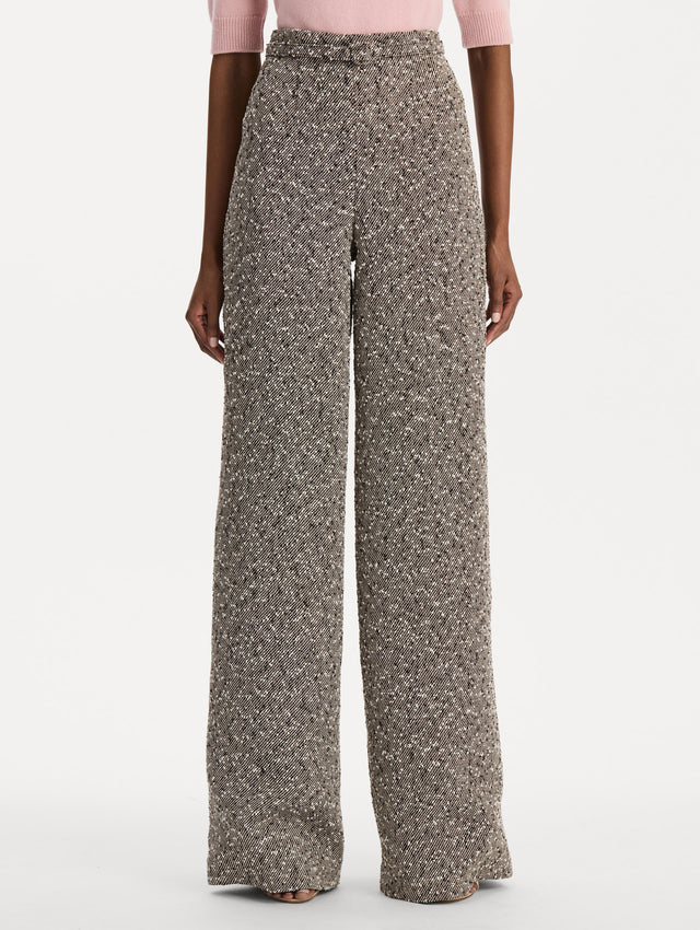 The model is wearing the slubby wool tweed gauze pant with a tailored silhouette in an ivory and brown palette. Front view. 