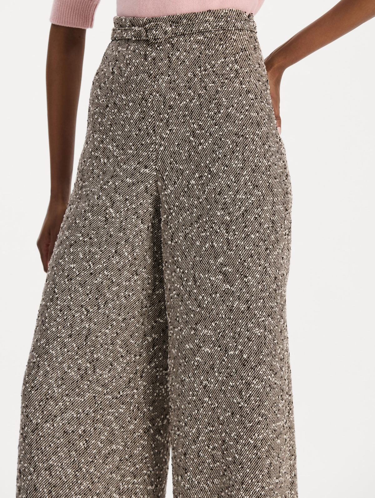 The model is wearing the slubby wool tweed gauze pant with a tailored silhouette in an ivory and brown palette. Zoom view. 