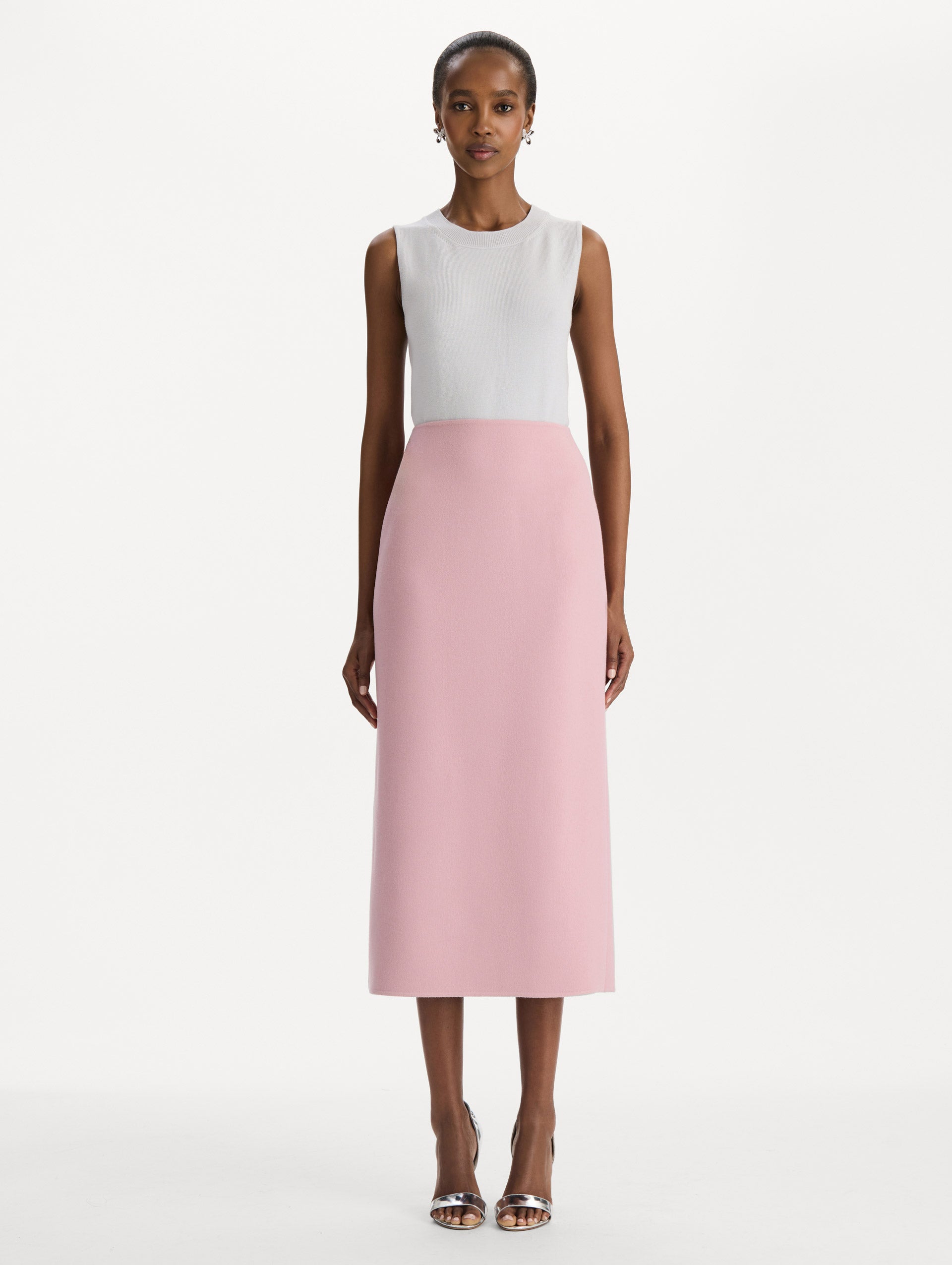 The model is wearing the wool pencil skirt with a structured silhouette in the color blush. Front view. 