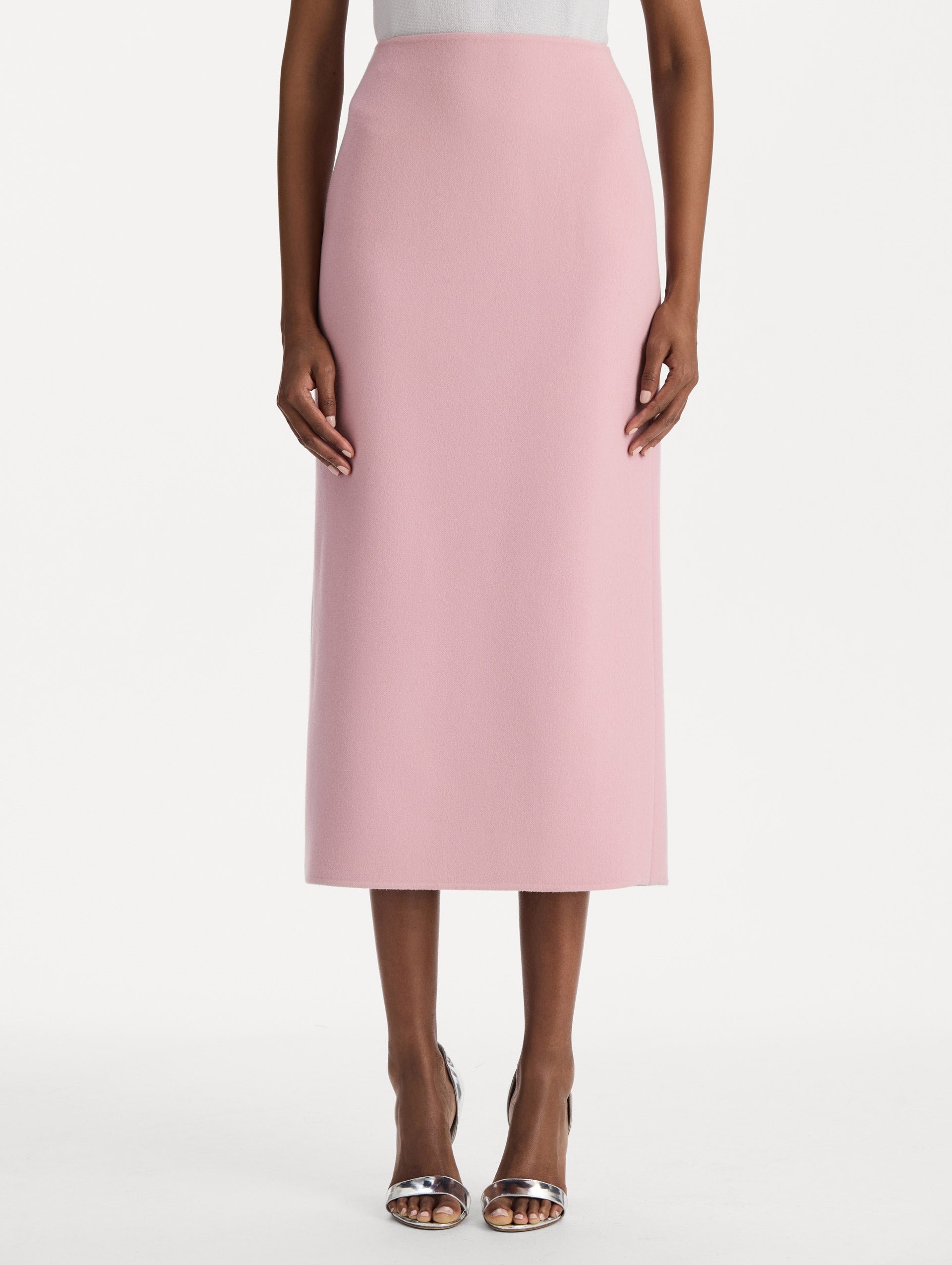 The model is wearing the wool pencil skirt with a structured silhouette in the color blush. Front view. 