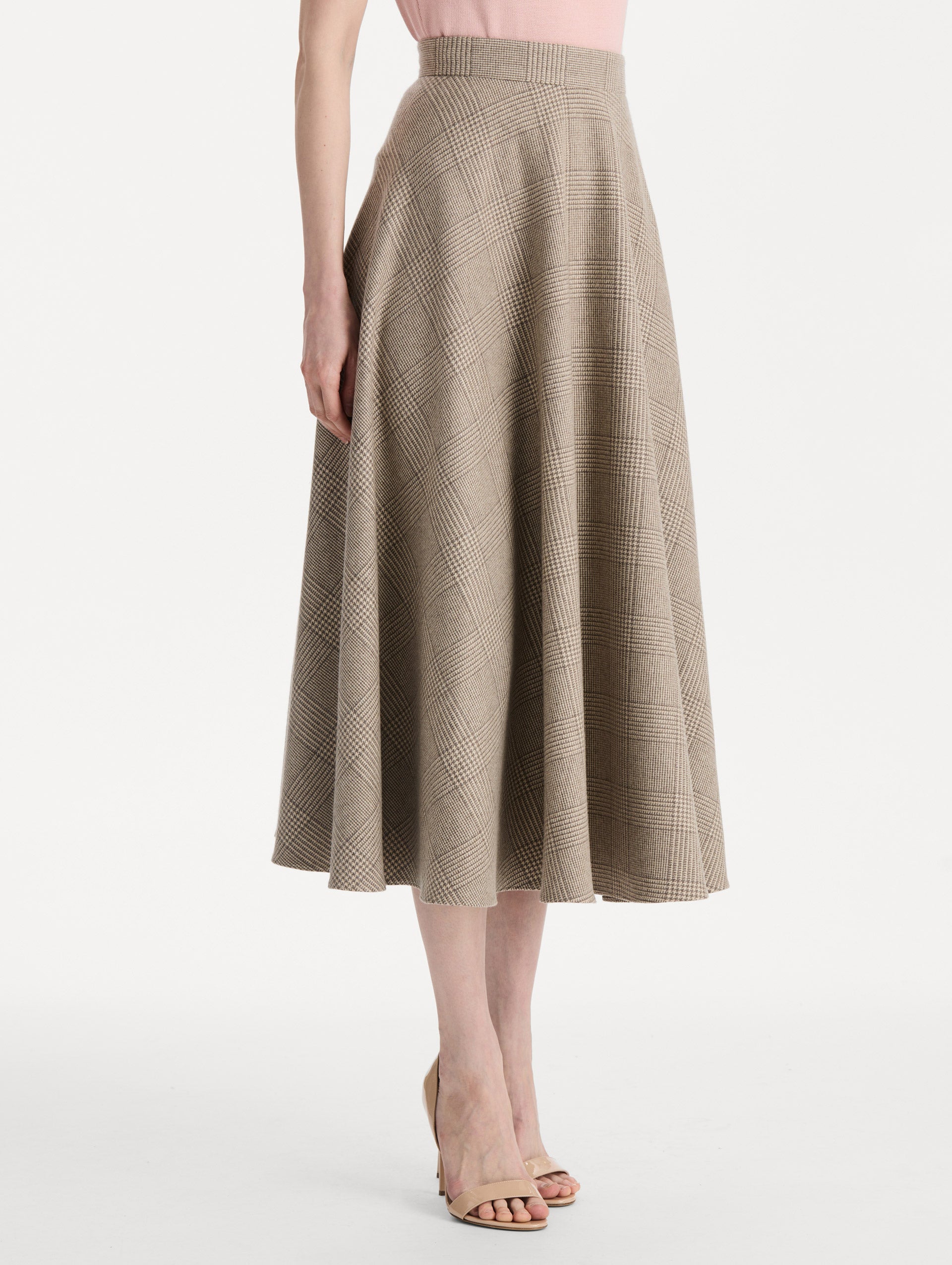 The model is wearing the plaid cashmere-blend skirt with a glen plaid pattern. Side view. 