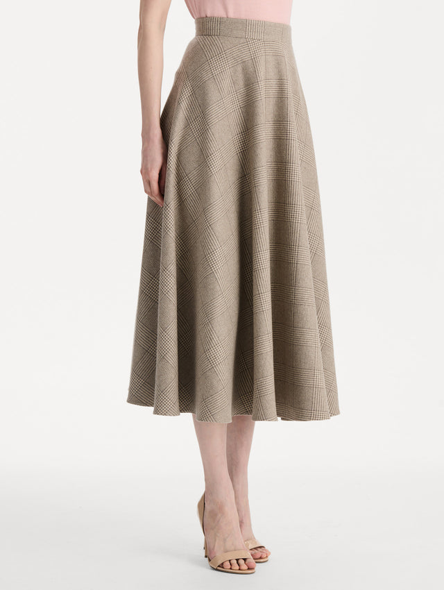 The model is wearing the plaid cashmere-blend skirt with a glen plaid pattern. Side view. 