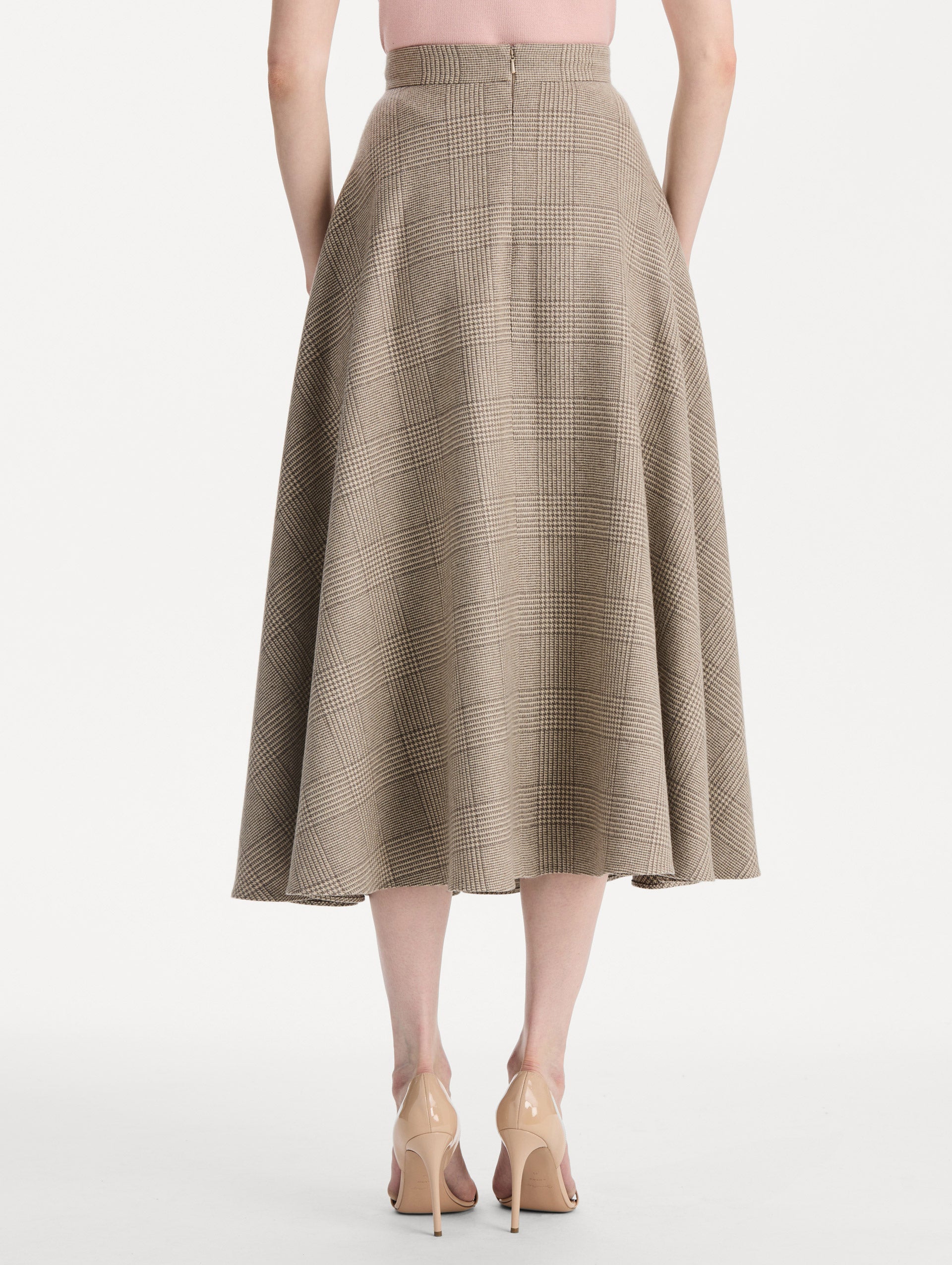 The model is wearing the plaid cashmere-blend skirt with a glen plaid pattern. Back view. 