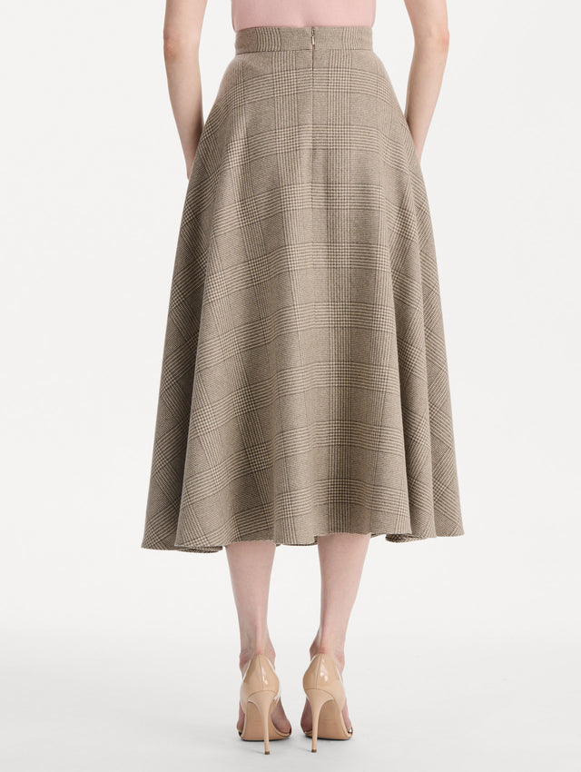 The model is wearing the plaid cashmere-blend skirt with a glen plaid pattern. Back view. 
