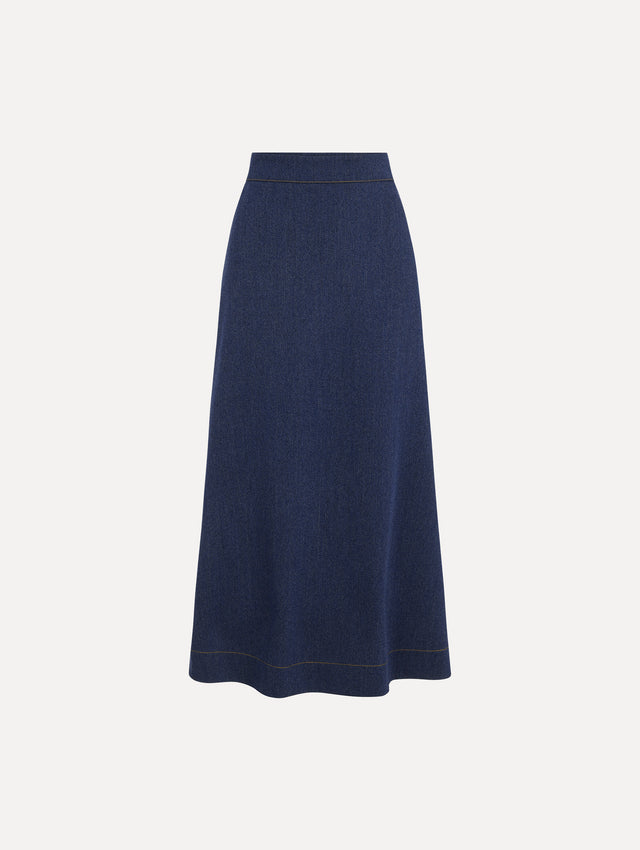 The model is wearing the wool midi skirt in indigo wool with a tailored silhouette. 