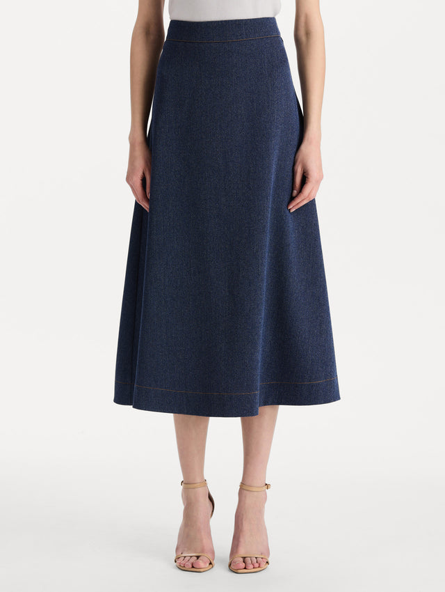 The model is wearing the wool midi skirt in indigo wool with a tailored silhouette.  Front view. 
