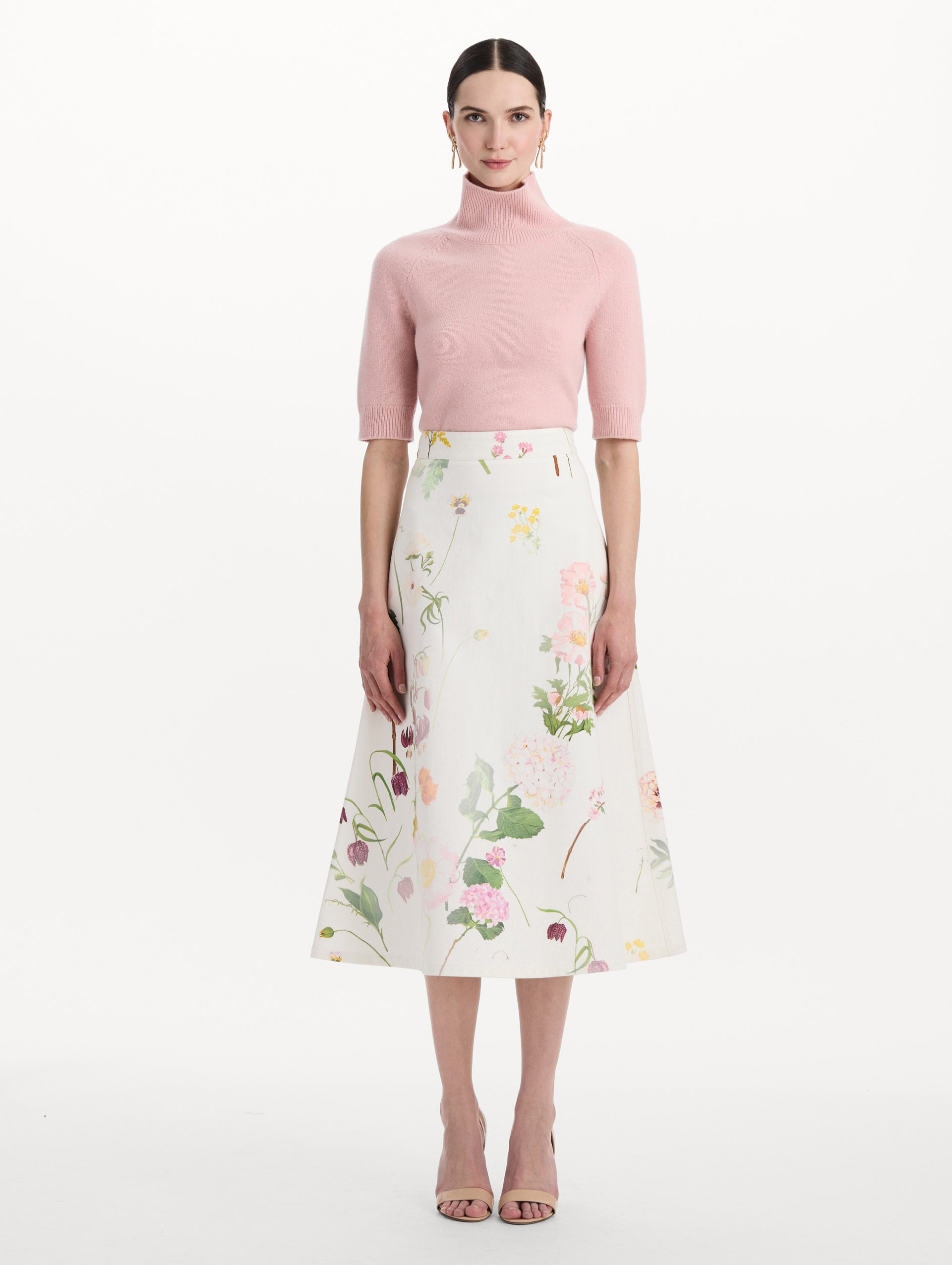 The model is wearing the faded mixed botanical denim midi skirt in the color white multi. Front view.